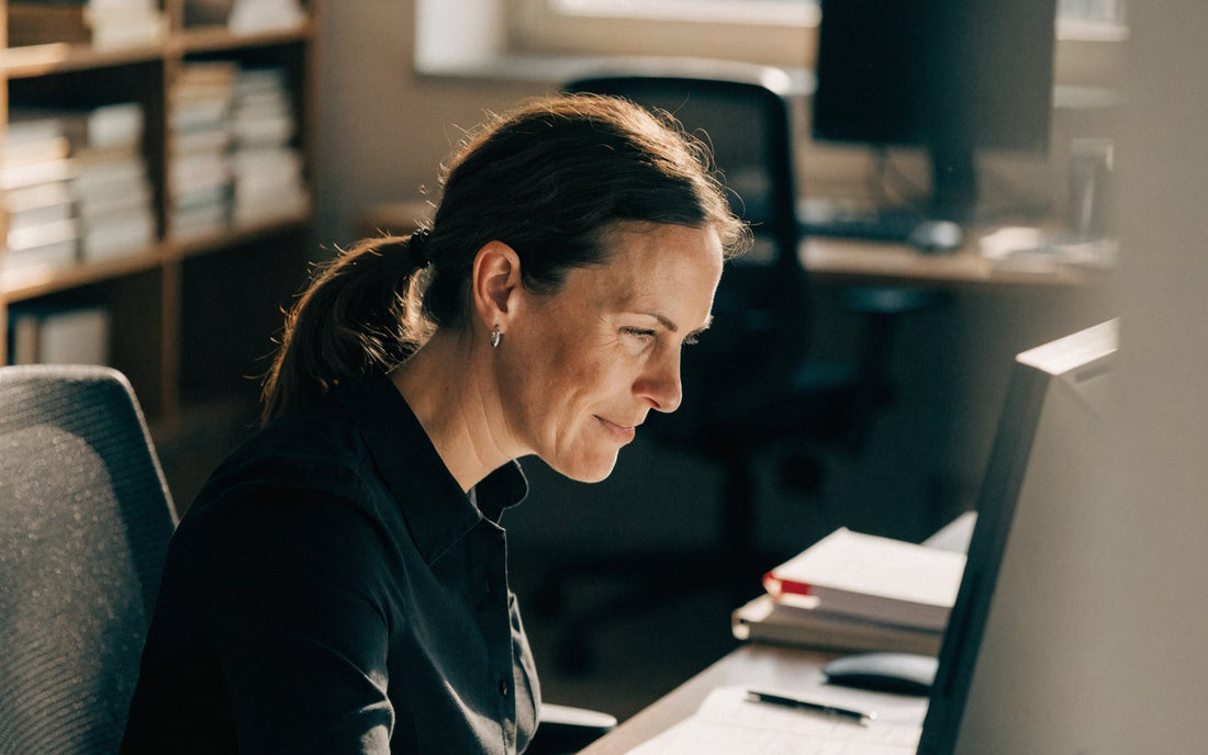 Woman focused at her desk in a sunlit office